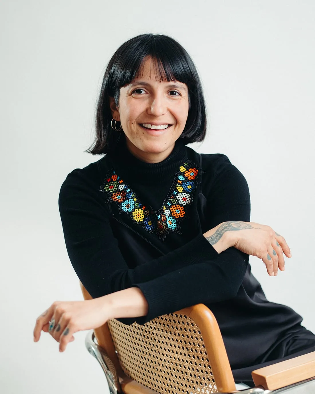Joan seated and laughing, one arm resting over the back of a chair.